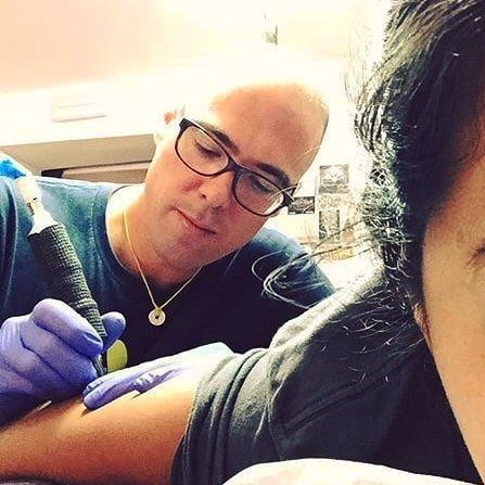 Skeenee working on a tattoo.